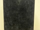 a black plaque on a wooden table with a white wall in the background