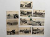 Plusieurs vieilles photographies de navires sont accrochées sur un mur blanc