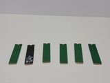a close up of four pieces of green plastic on a white surface