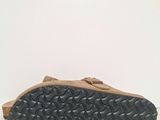 a close up of a pair of brown shoes on a white surface