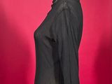 black jacket on a mannequin stand against a red background