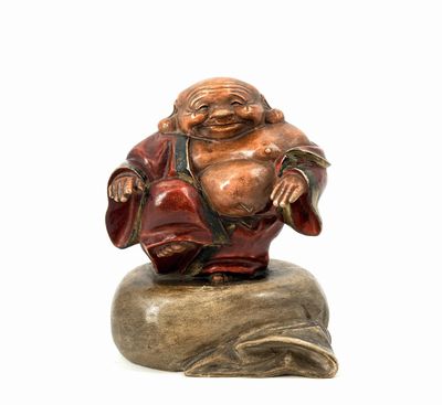 statue of a laughing buddha sitting on a rock on a white background