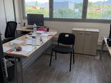 a room with a desk, chairs, and a computer on it