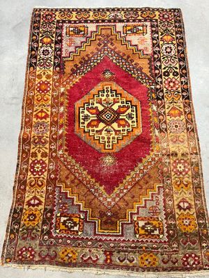 an old rug with a red and yellow design on it