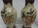two vases that have been painted with flowers on them