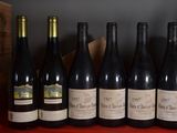 six bottles of wine are lined up in a row on a table