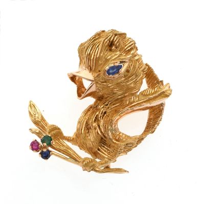 une broche en or ornée d'un oiseau et d'une fleur