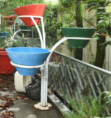 un seau bleu et rouge posé sur un support blanc