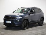 a grey jeep compass parked in a room with a checkered floor