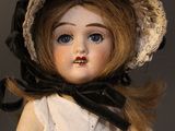 a doll that is wearing a hat and a dress