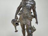 bronze statue of a man holding a watering can and a dog