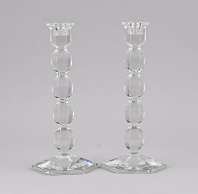 pair of clear glass candlesticks sitting on top of a table