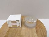 a picture of a jar of cream sitting on a wooden tray