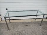 a glass table with metal legs and a glass top