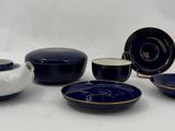 five bowls and a pitcher on a white table