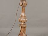 une lampe de table ancienne en bois sur laquelle est posée une bougie blanche