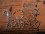 a wooden plaque with a horse drawn carriage on it