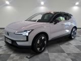 La voiture électrique blanche est garée dans une grande pièce.