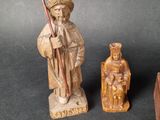 two wooden figurines of a man and a woman with a staff