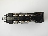 an overhead view of a black train engine on a white surface