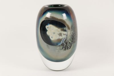 a black and white vase sitting on a white surface