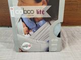 the box of the baby carrier is open on the bed