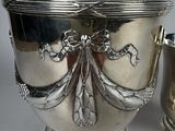 a silver bowl and a silver cup on a table