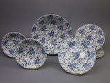 trois assiettes bleues et blanches ornées de fleurs, posées sur un fond gris