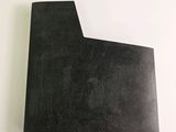 two pieces of black paper sitting on top of a white table