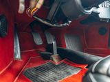 a close up of a car ' s floor with a red carpet