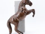 statue d'un cheval debout sur ses pattes arrière, à côté d'une boîte