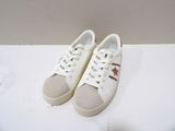 pair of white sneakers with brown stars on them sitting on a white surface