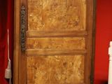 une armoire en bois dans une pièce rouge, avec des assiettes par terre
