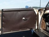 a brown and white suitcase sitting in the back of a car