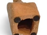 a clay animal that is sitting inside of a small house