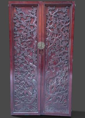 an image of a wooden cabinet with carvings on the doors