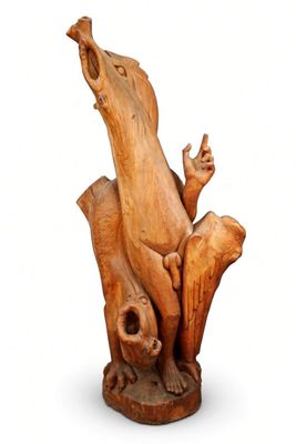 a wooden sculpture of a bird sitting on a tree stump