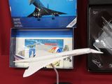 une maquette d'avion à réaction posée sur une table à côté d'une boîte