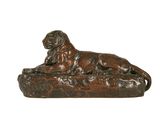 statue en bronze représentant un chien couché sur un rocher