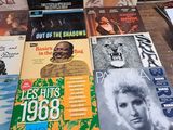 several records are sitting on a table in front of a window