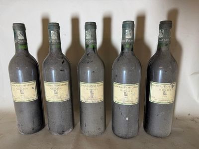 six bottles of wine are lined up on a shelf