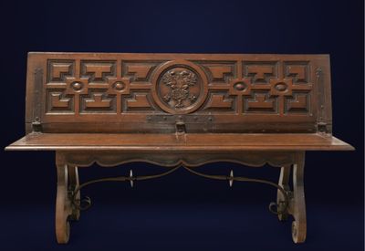 un vieux banc en bois orné d'un motif sculpté
