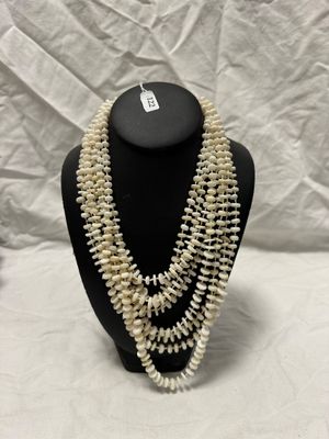 a close up of a necklace with pearls on a mannequin