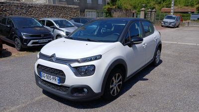 une petite voiture blanche garée dans un parking
