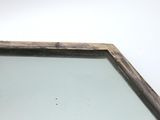 a mirror with a wooden frame on a white wall