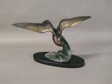 statue of a bird on a black base on a white background