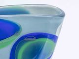 a blue and green glass vase with two circles on it