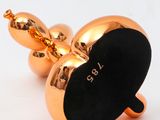 a gold apple shaped object on a white surface