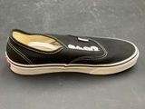 vans slip - on shoes with white soles on a gray surface