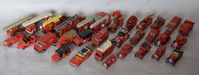 a lot of toy firetrucks and trucks on a white surface